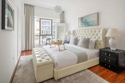 a white bedroom with a large bed and a window at Frank Porter - RBC Tower in Dubai