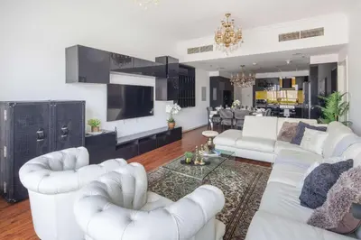 a living room with white couches and a kitchen at Frank Porter - RBC Tower in Dubai