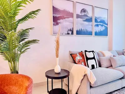 a living room with a couch and a vase on a table at Canal Front - Luxury 2BR Stay in Al Wasl in Dubai