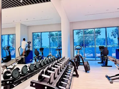 a gym with a bunch of treadmills and machines at Canal Front - Luxury 2BR Stay in Al Wasl in Dubai