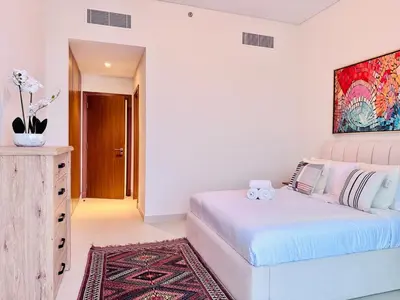 a bedroom with a bed and a painting on the wall at Canal Front - Luxury 2BR Stay in Al Wasl in Dubai