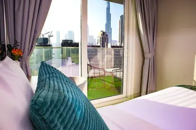 a bedroom with a bed and a window with a view at Stunning Burj View - Cozy 2BR - 5 min Dubai Mall in Dubai