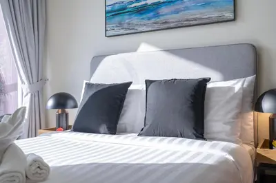 a bedroom with a bed with gray and white pillows at Stunning Burj View - Cozy 2BR - 5 min Dubai Mall in Dubai