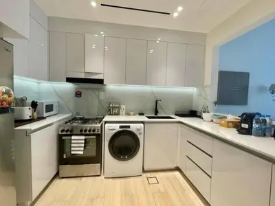 a kitchen with a washer and a stove at Chic & Serene 1br Apt Balcony, Pool & Parking in Dubai