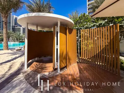 a building with a wooden fence and a pool at LUX The Dubai Creek Beach Suite in Dubai
