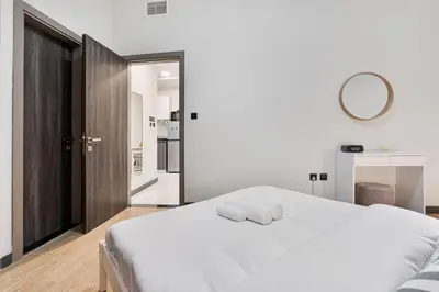 a bedroom with a white bed with two towels on it at Stunning 1BR APT in Rukan with Gym and Pool in Dubai