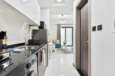 a kitchen with a sink and a refrigerator at Stunning 1BR APT in Rukan with Gym and Pool in Dubai