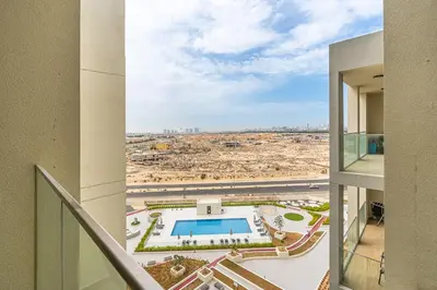 a view from the balcony of a building with a pool at Stunning 1BR APT in Rukan with Gym and Pool in Dubai
