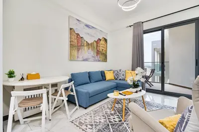 a living room with a blue couch and a table at Stunning 1BR APT in Rukan with Gym and Pool in Dubai