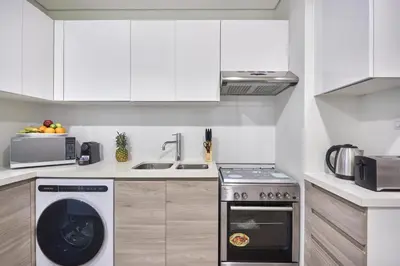 a kitchen with a washing machine and a sink at Luxury Studio - SOL BAY Tower - Business Bay by Stayfinity in Dubai