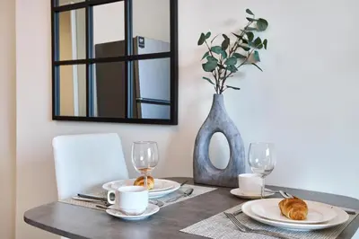 a dining room table with two plates and a mirror at Luxury Studio - SOL BAY Tower - Business Bay by Stayfinity in Dubai