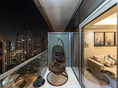a chair on a balcony with a view of a city at Stunning Burj View - High Infinity Pool - Cozy 2BR in Dubai