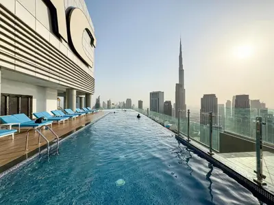 a swimming pool on top of a building with a city skyline at Stunning Burj View - High Infinity Pool - Cozy 2BR in Dubai