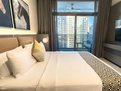a bedroom with a large white bed with a window at Cozy Studio in Business Bay in Dubai