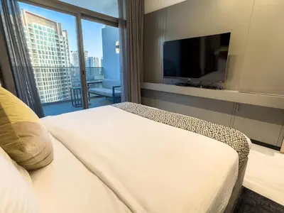 a hotel room with a bed and a flat screen tv at Cozy Studio in Business Bay in Dubai