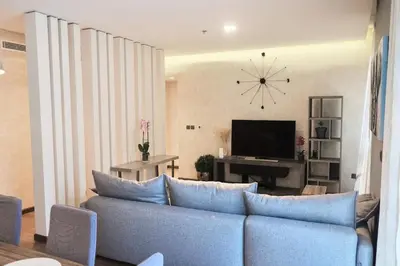 a living room with a couch and a clock on the wall at Elegant 2BR in Dubai Marina in Dubai