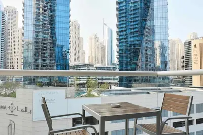 a table and chairs on a balcony with a view of a city at Elegant 2BR in Dubai Marina in Dubai