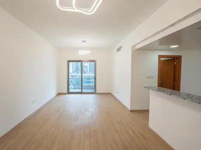 an empty living room with white walls and wood floors at Amiqa Homes Dubai Marina in Dubai