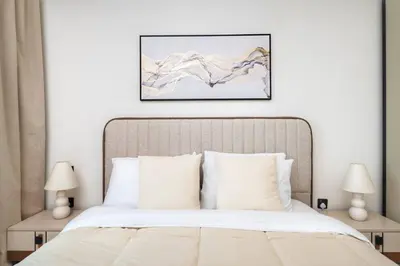 a bedroom with a large bed with two lamps at Seafront-side apartment with beach access, pool, gym, high floor in Dubai