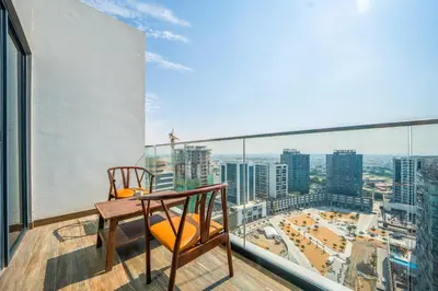 a balcony with a table and chairs and a view of the city at Cozy Studio Pool & Gym Near Burj Khalifa & Racecourse views in Dubai
