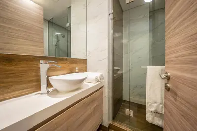 a bathroom with a sink and a glass shower at Cozy Studio Pool & Gym Near Burj Khalifa & Racecourse views in Dubai