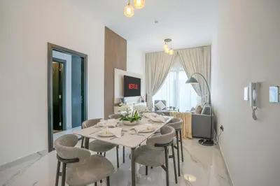 a dining room and living room with a table and chairs at New Family-Friendly 2BR with Gym and Pool and Sauna in Dubai