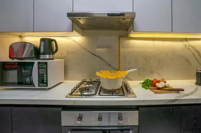 a kitchen with a microwave and a stove top oven at New Family-Friendly 2BR with Gym and Pool and Sauna in Dubai