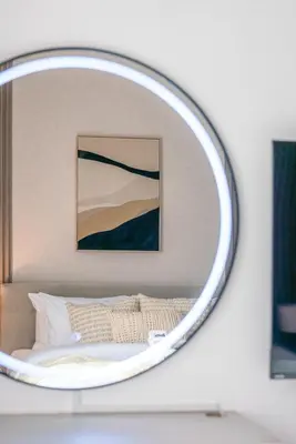 a mirror above a bed in a bedroom at New Family-Friendly 2BR with Gym and Pool and Sauna in Dubai
