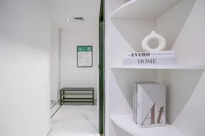 a room with a mirror and a book on a shelf at New Family-Friendly 2BR with Gym and Pool and Sauna in Dubai