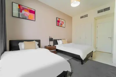 a bedroom with two beds and a window and a door at Cozy 2BR Villa in Damac Hills 2 by deleguest in Dubai