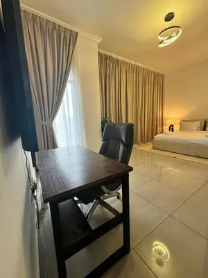 a room with a desk and a chair and a bed at Swarg Stay in heart of Dubai in JVC in Dubai