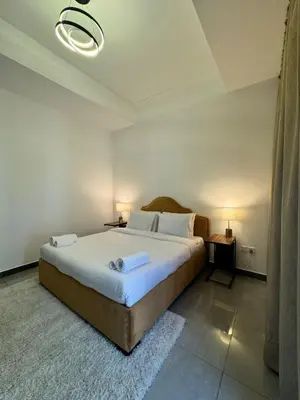 a bedroom with a large bed with two tables and two lamps at Swarg Stay in heart of Dubai in JVC in Dubai