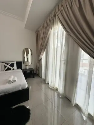 a bedroom with a bed and large windows at Swarg Stay in heart of Dubai in JVC in Dubai