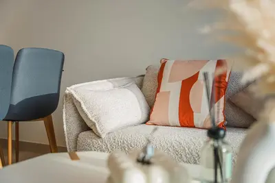 a living room with a couch and a chair at Elegant 1BR Apt in JVC Dubai with Spacious Balcony & City Views in Dubai