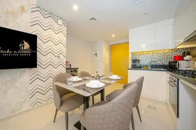 a kitchen and dining room with a table and chairs at Modern Sunset View 2Bhk 6pax in Dubai