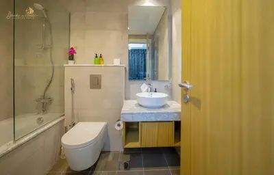 a bathroom with a toilet and a sink and a tub at Modern Sunset View 2Bhk 6pax in Dubai