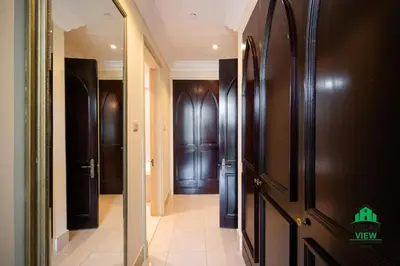 a hallway with dark wood doors and a hallway with a mirror at Souk Al Bahar - Burj Khalifa - Dream View Holiday Home Rental in Dubai