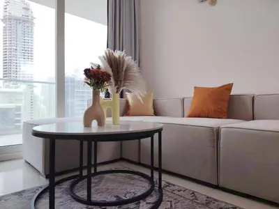 a living room with a couch and a table at Burj View 2BR Near Dubai Mall Fast Wi-Fi Balcony in Dubai