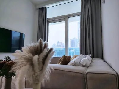 a living room with a couch and a large window at Burj View 2BR Near Dubai Mall Fast Wi-Fi Balcony in Dubai