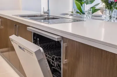 a dishwasher in a kitchen under a sink at High Floor Apartment with full Burj Khalifa View, Opera & Fountain - Downtown Dubai - Forte Tower by Stayfinity in Dubai