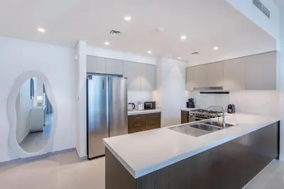 a kitchen with a refrigerator and a counter top at High Floor Apartment with full Burj Khalifa View, Opera & Fountain - Downtown Dubai - Forte Tower by Stayfinity in Dubai