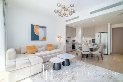 a living room with a white couch and a table at LUX The Orchid Creek Beach Suite in Dubai