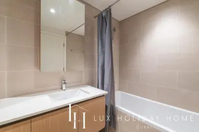 a bathroom with a sink and a bath tub at LUX The Orchid Creek Beach Suite in Dubai