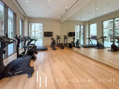 a gym with treadmills and exercise bikes in a room at LUX The Orchid Creek Beach Suite in Dubai