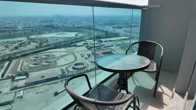 a table and chairs on a balcony with a view of a city at High Floor - Bright Elite Studio in Business Bay in Dubai