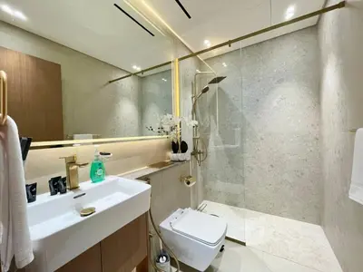 a bathroom with a toilet and a sink and a shower at Brand New Cozy 2br Apartment In Jvc With Balcony in Dubai