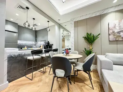 a kitchen and living room with a table and chairs at Vserve 1 BR Stay with Stunning Skyline Views in Dubai