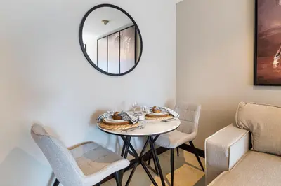 a dining room with a table with chairs and a mirror at Stylish JLT Studio Lake View PoolMarina Walk in Dubai
