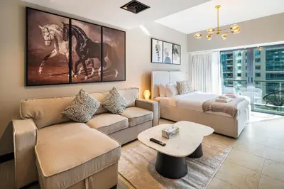 a living room with a couch and a bed at Stylish JLT Studio Lake View PoolMarina Walk in Dubai