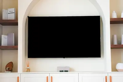a flat screen tv on a white wall at Luxe JLT 1BR Apt Gym Pool & Stunning Views in Dubai